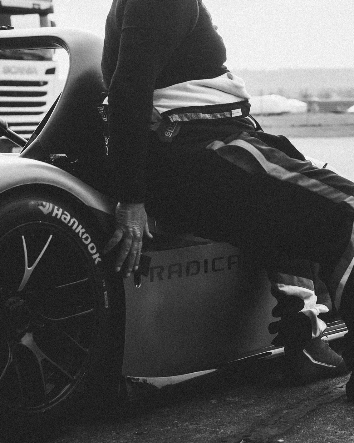 Race driver sitting on a Radical race car wheel